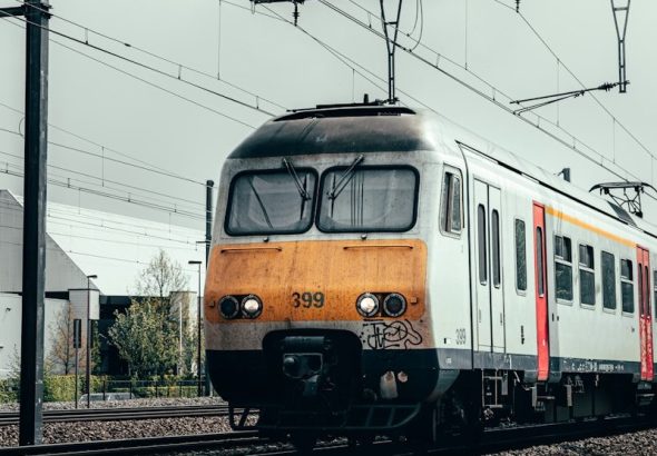 blue and orange train on rail tracks