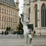 a statue of a man holding a book in front of a building