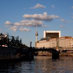 Stunning view of Berlin with TV Tower at sunset reflecting on the river.