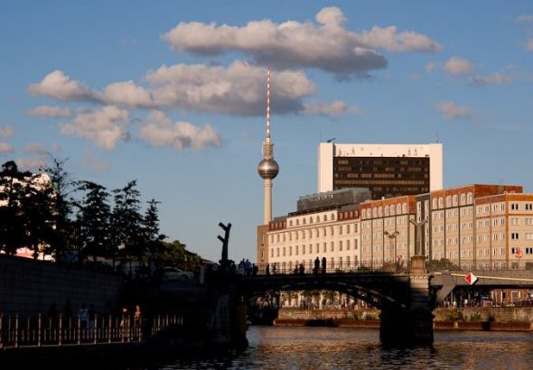 Stunning view of Berlin with TV Tower at sunset reflecting on the river.